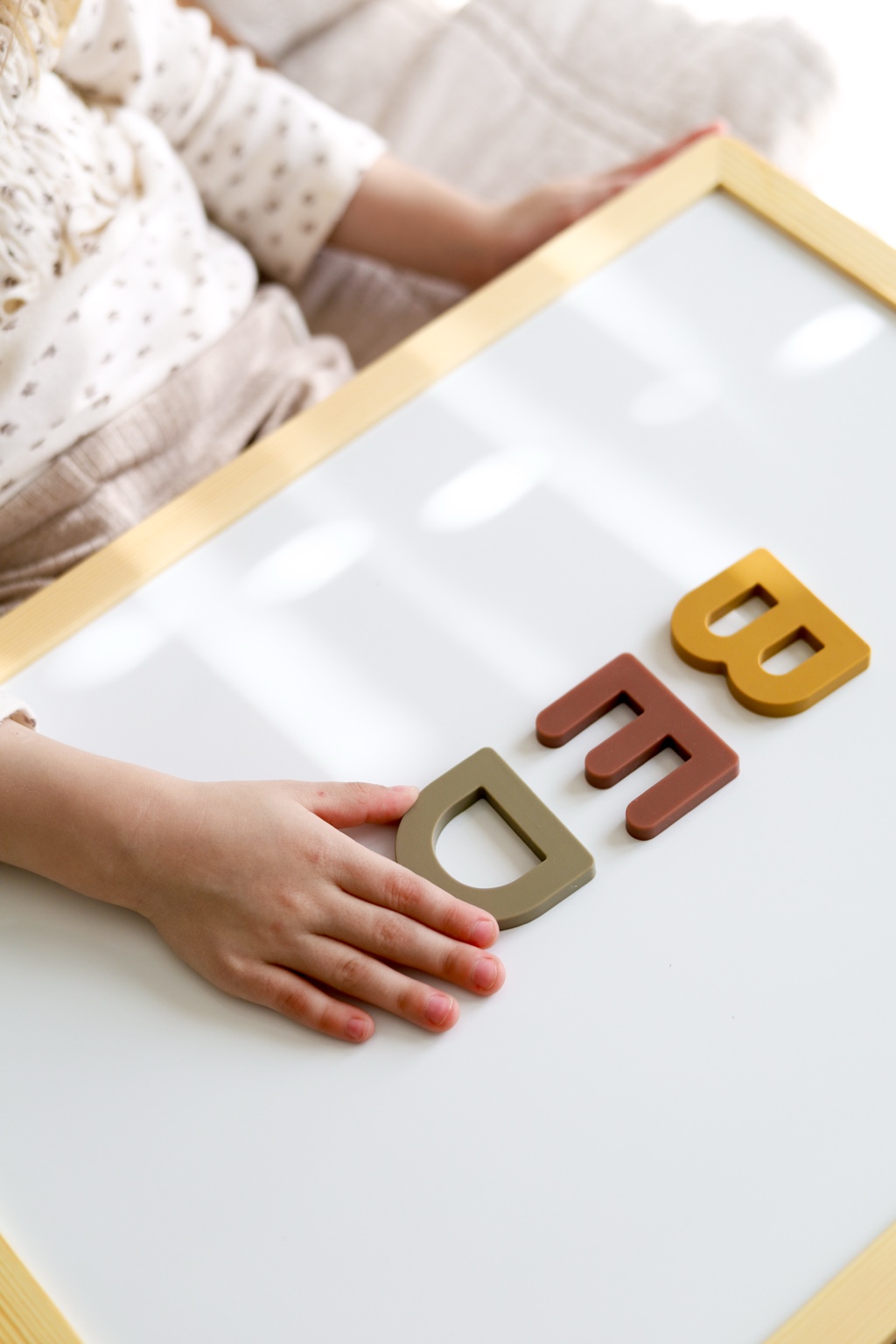 Child interacting with magnetic letters