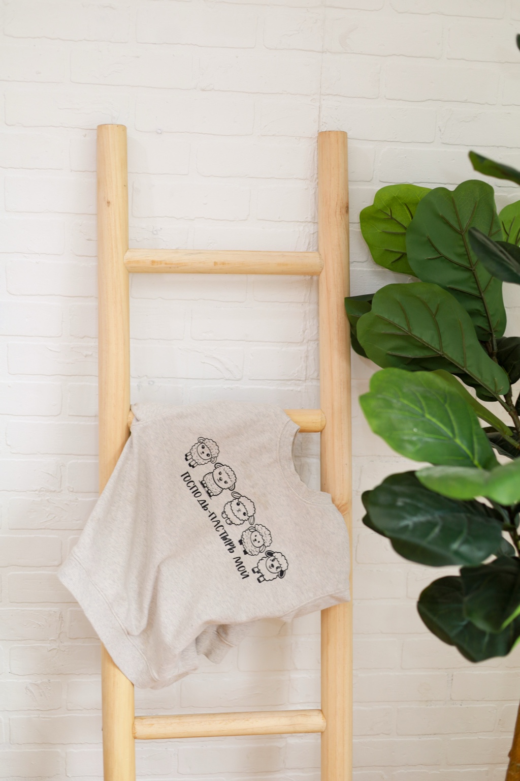 Handmade knit displayed on a wooden ladder