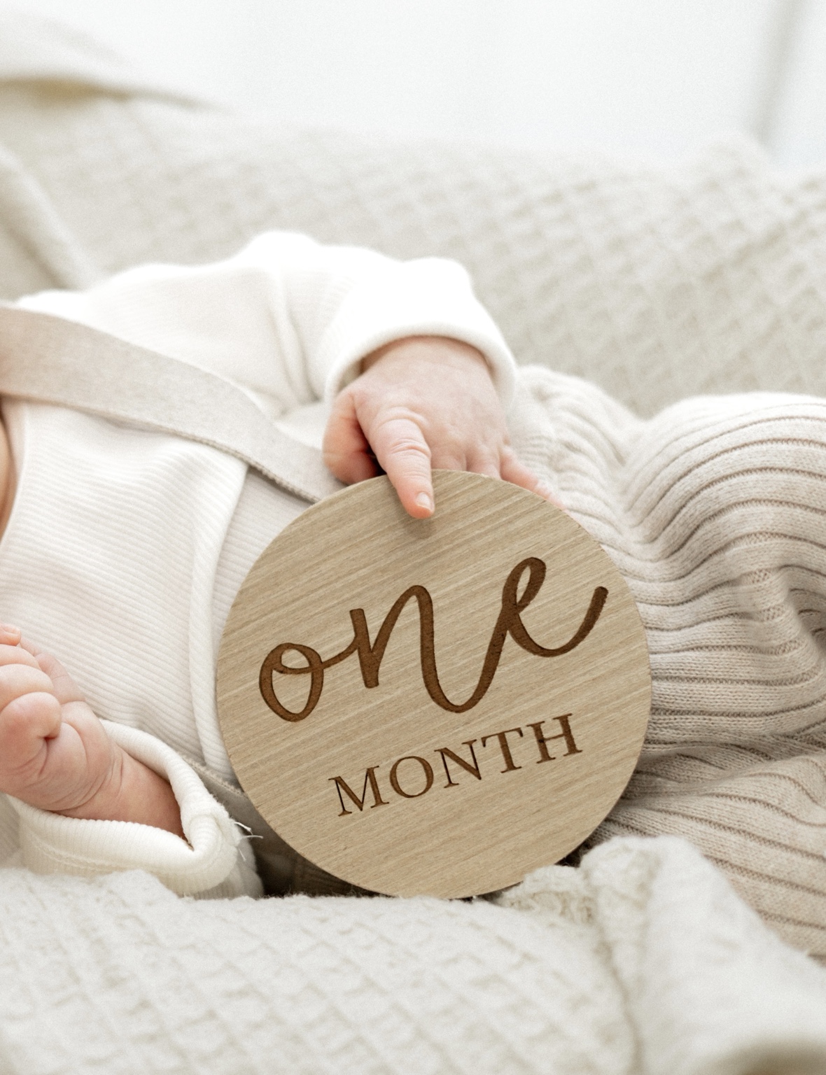One month milestone disc styled with a baby in soft neutrals